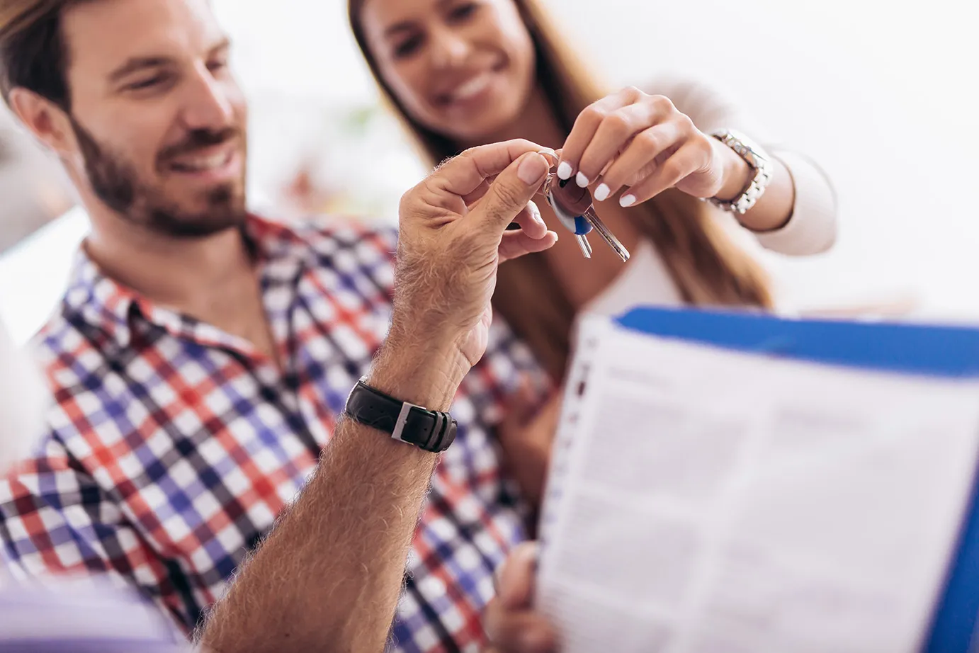 image of a couple receiving keys to their new home, along with a Certificate of Title proving ownership of their new home