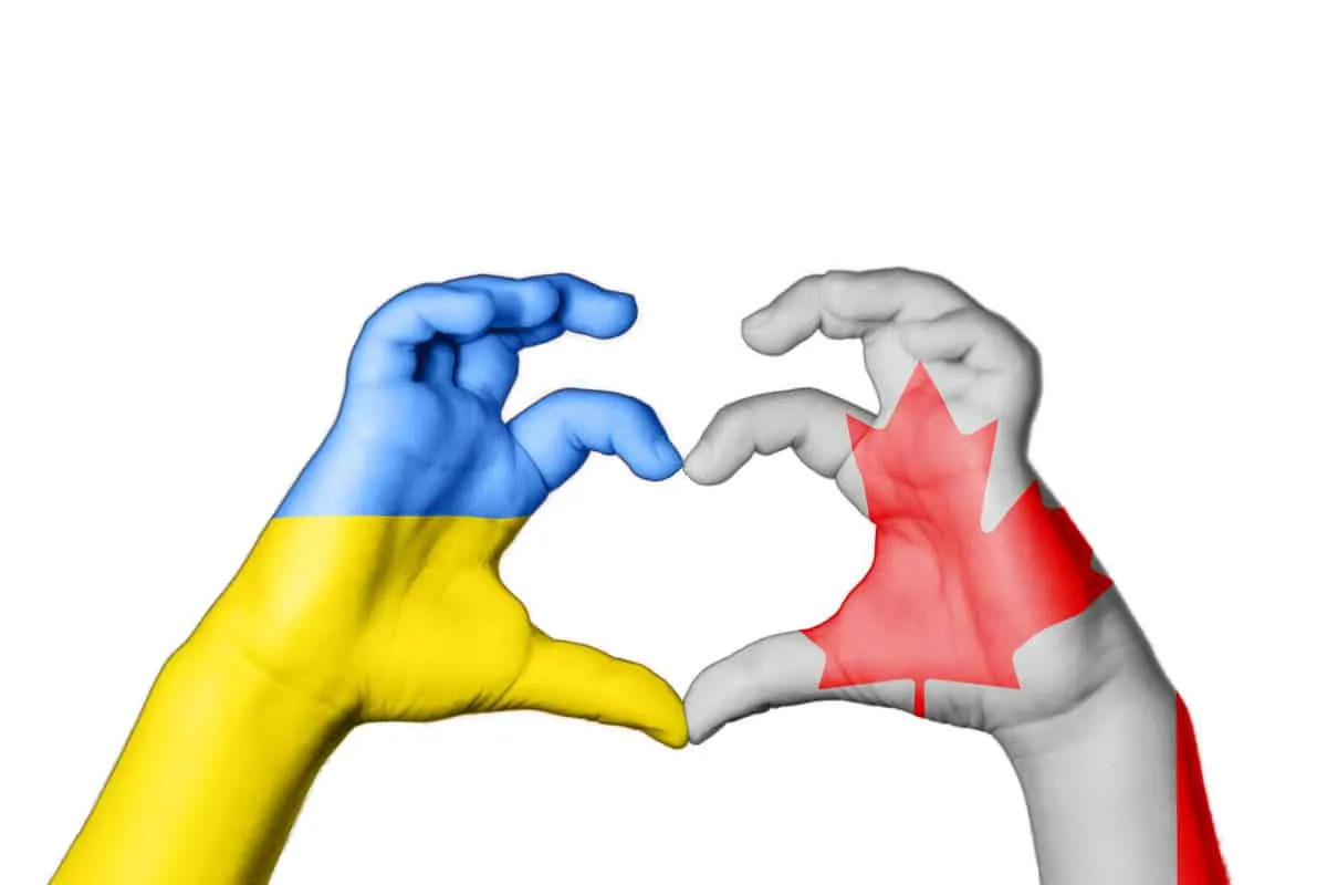 photo of two hands shaped as a heart, an image with Ukraine's flag and Canada's flag, depicting Canada and Ukraine as partners to assist the people of Ukraine with protection from war.