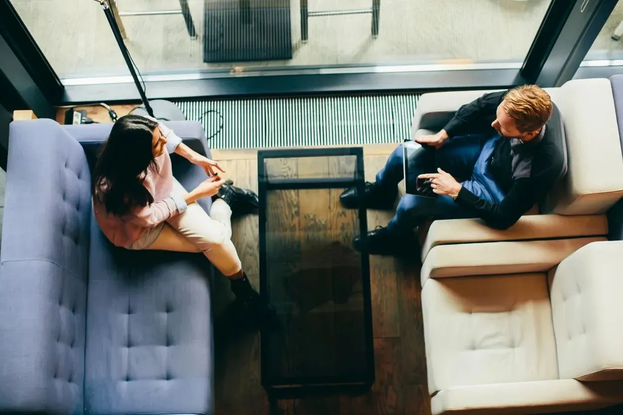 photo of a separated couple discussing the terms of their divorce in an amicable fashion to avoid high court costs and emotional strain on their children.